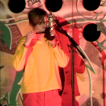 Anaël Honings jouant de l'harmonica devant un micro